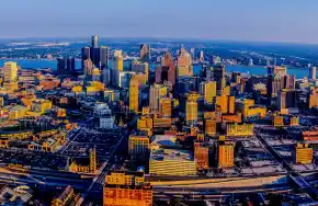 Aerial view of a vibrant city skyline with golden-hued buildings and busy streets.